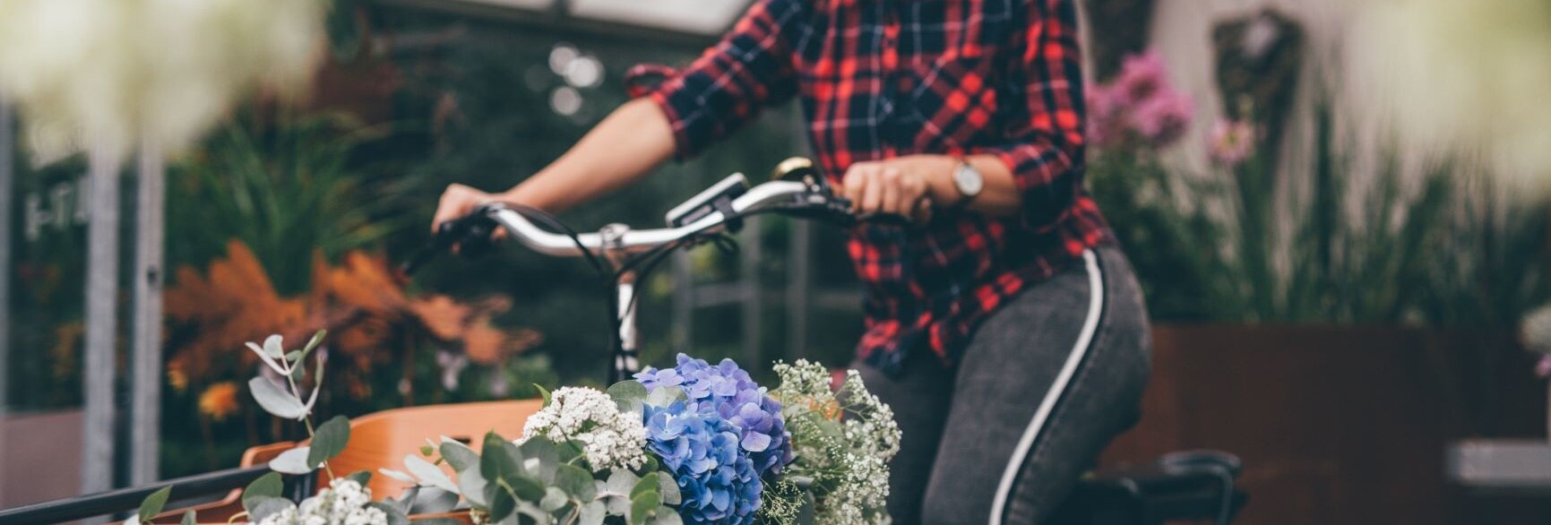 Eine Mitarbeiterin fährt die liebevoll gesteckten Blumen mit dem Rad aus