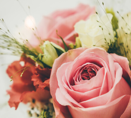 Nahaufnahme einer rosafarbenen Rose in einem geschmackvollen Blumenstrauß