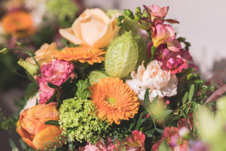 Ein aufwendiger Blumenstrauß aus orangen, grünen und rötlichen Blüten