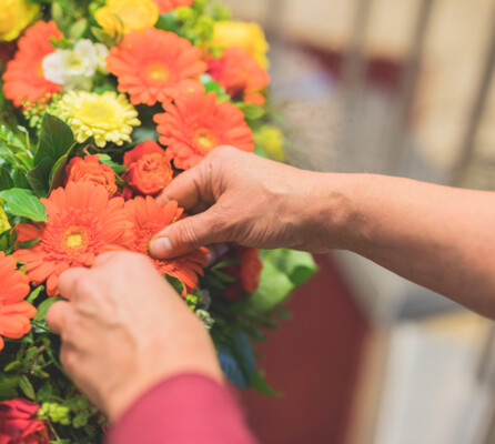 Detailaufnahme von einem Blumenkranz mit orangefarbenen Gerbera.