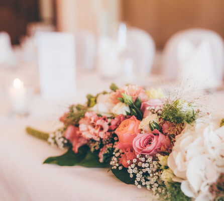 Ein liebevoll gestaltetes Tischarangement aus verschiedenen weißen und rötlichen Blumen